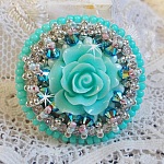 Bague Blue Flowers brod&eacute;e avec un cabochon en forme de rose en r&eacute;sine, cha&icirc;ne strass Cristal, toupies Jet de haute qualit&eacute; AB2X et farfalles ovales. Les couleurs sont : l&rsquo;Argent&eacute; et le Vert Menthe